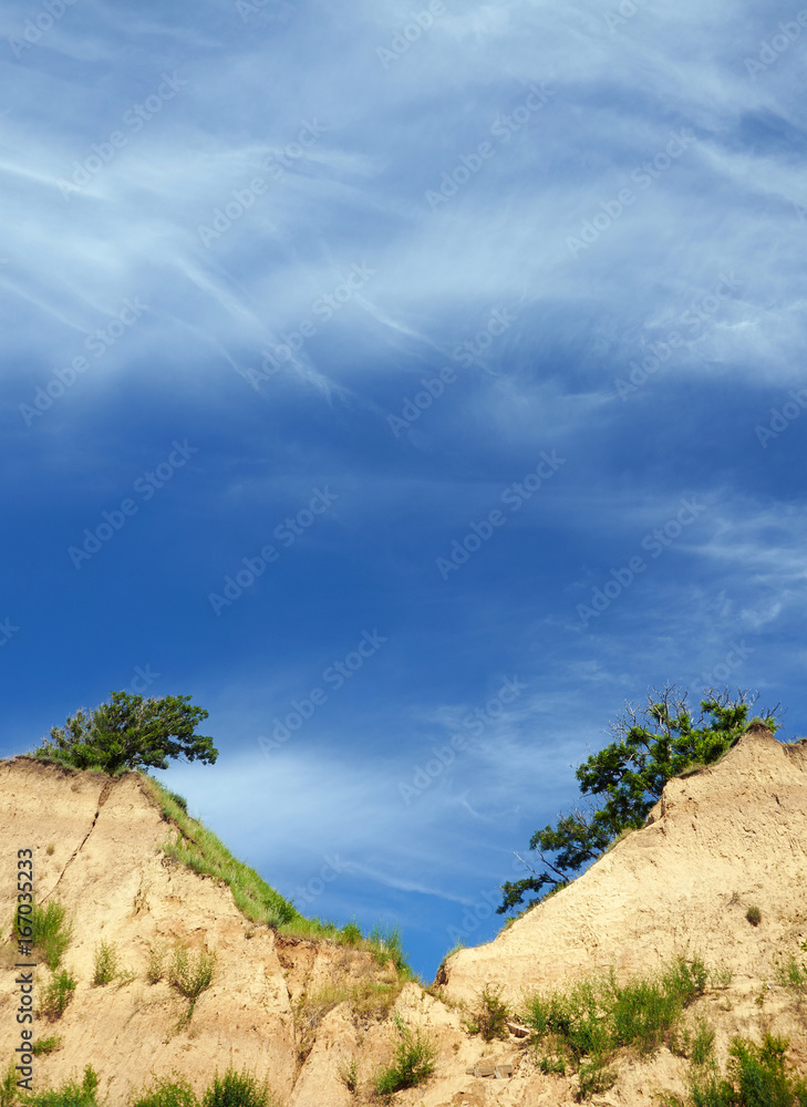 Clear blue sky and twin cliff peaks with trees