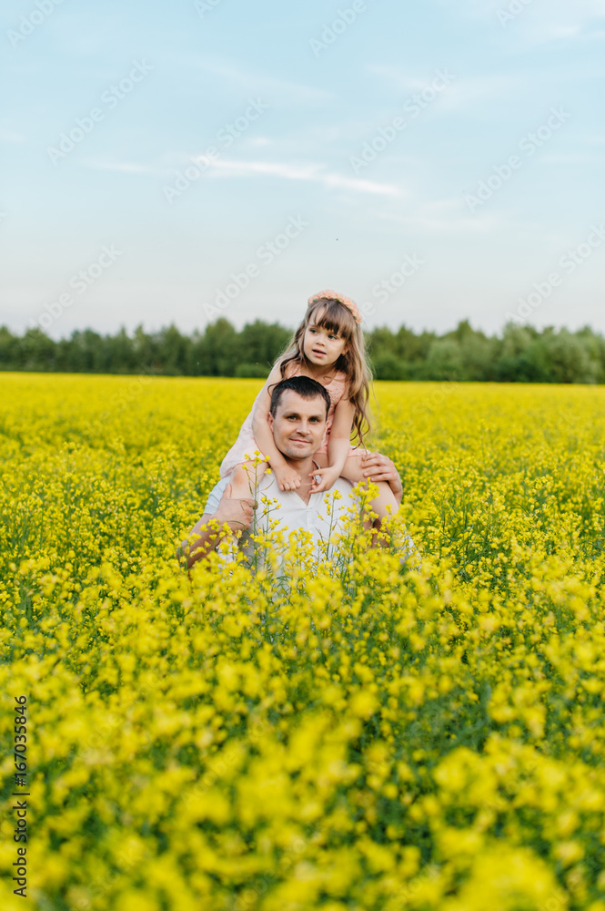Man with child in a yellow field at sunset Man with child in a yellow field at sunset