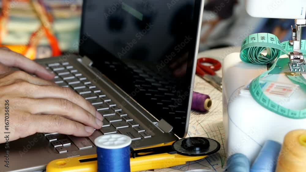 Seamstress sitting in her studio and typing something on laptop
Seamstress sitting in her studio and typing something on laptop