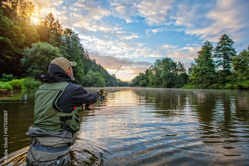 Fotografie, Obraz Sport fisherman hunting fish. Outdoor fishing in river