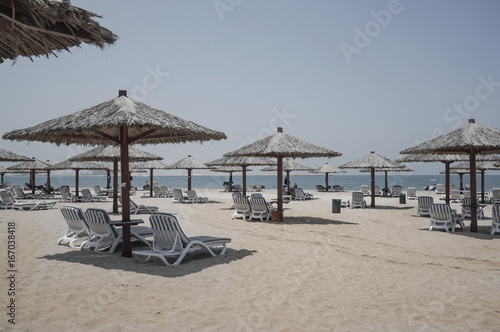 Dubai. Heavenly oasis in Ras al Khaimah. The beach with sunbeds and sunshades in Dubai  on the shores of the Arabian Gulf. Toning.  