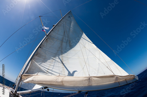 Wide-angle view of sail against blue sky.