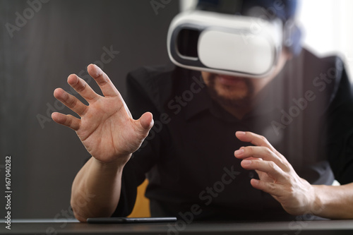 businessman wearing virtual reality goggles in modern office with Smartphone using with VR headset