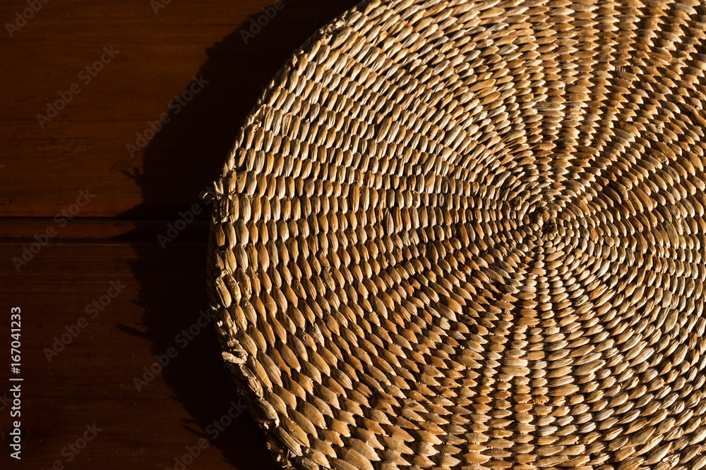 Fototapeta premium An abstract close up background of a hand woven, spiral, textured wicker grass mat.