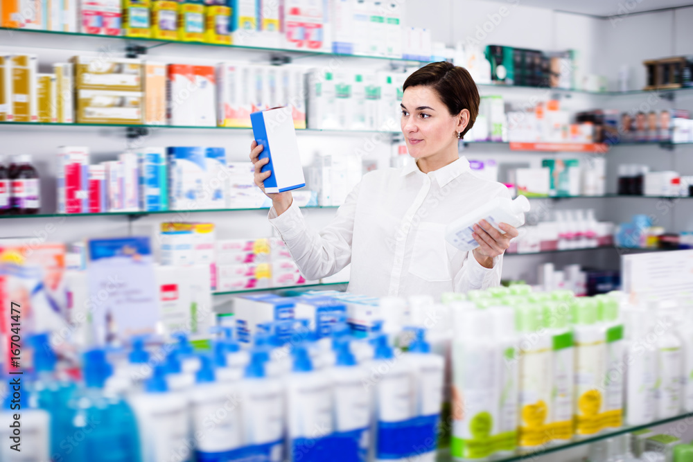 Young woman customer browsing rows of drugs