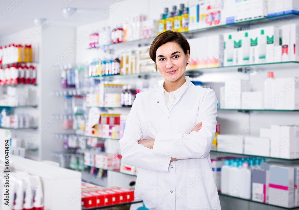 Smiling female pharmacist demonstrating assortment of pharmacy