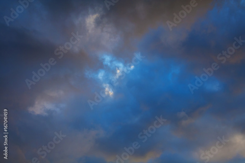 Dark clouds in the evening azure sky (background)