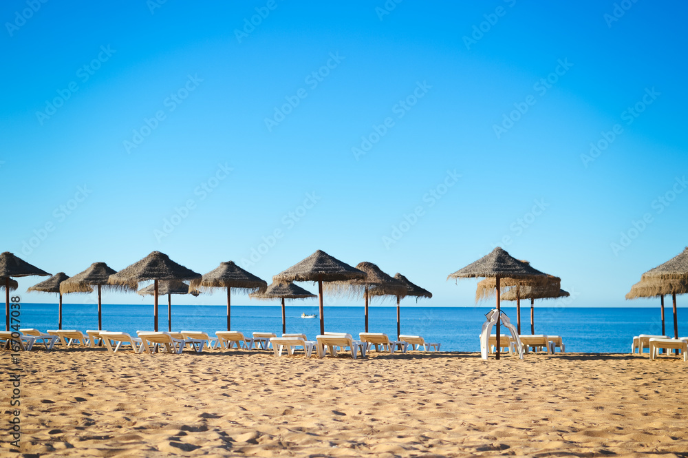 Fototapeta premium Sunny sky and chairs with parasol on the beautiful beach of Portugal