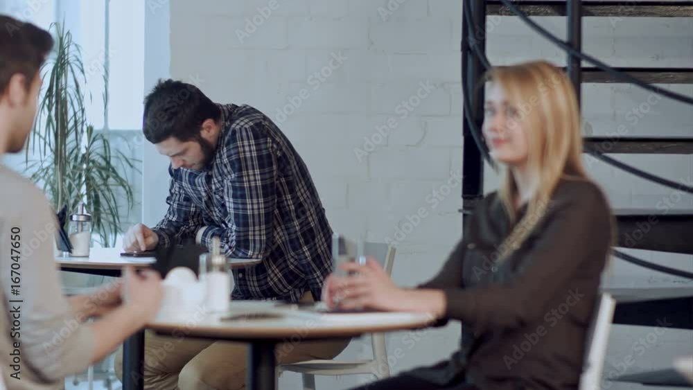 Worried young man using tablet computer in cafe, sitting alone Worried young man using tablet computer in cafe, sitting alone