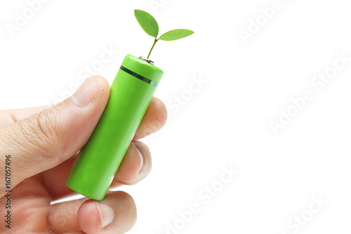 Hand holding a green rechargeable aa battery with a green small plant - Using  environmentally friendly product concept photo