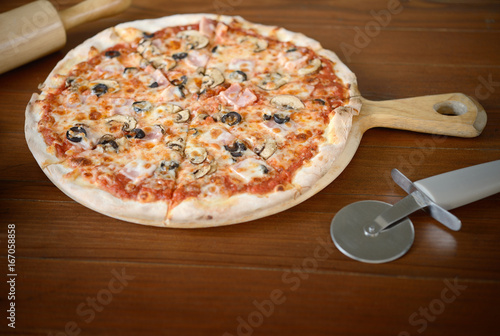 Fresh baked pepperoni delicious italian pizza served on wooden table.