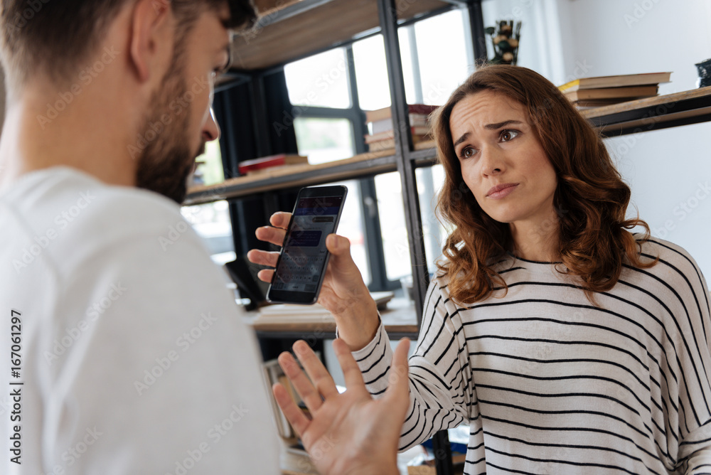 © zinkevych - Sad unhappy woman showing a message to her boyfriend