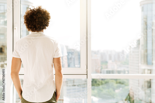 Free Download Handsome man standing near window indoors. - GFXLoad