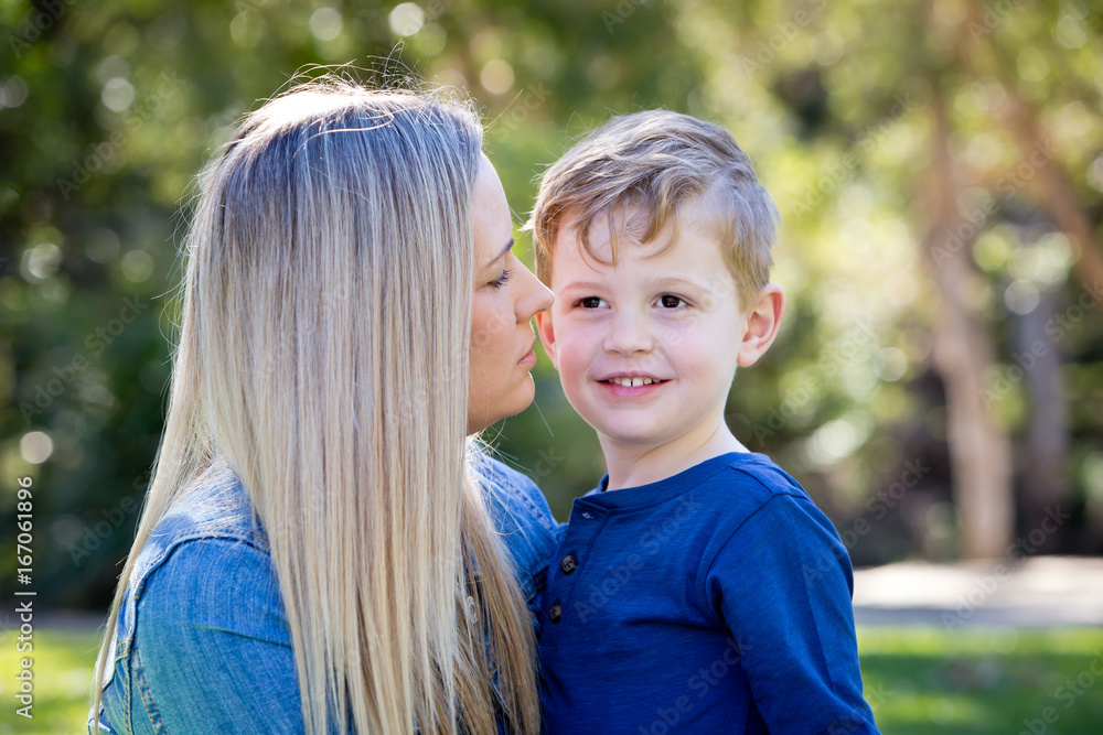 Fototapeta premium Mother and young son embracing and sharing time together outdoors