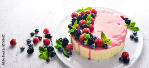 Cake with butter and fresh berries and fruits. Dessert. On a wooden background. Top view. Free space for your text.