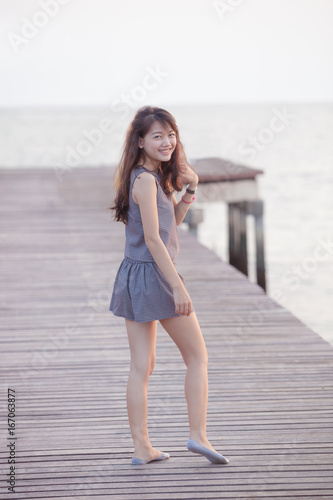 portrait full slim body  with toothy smiling face asian woman relaxing on beach
