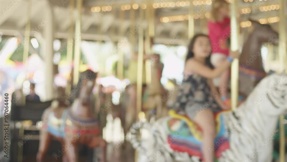 Soft focus people riding a carousel at an amusement park Soft focus people riding a carousel at an amusement park
