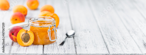 Portion of Apricot Jam on wooden background (selective focus)