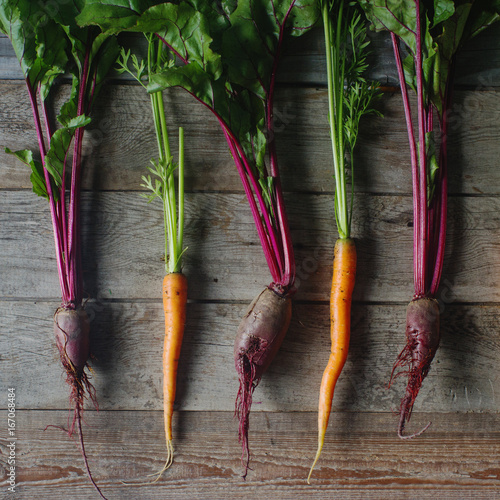 Fresh organic beet and carrot on rustic wooden background, healthy lifestyle, autumn harvest, raw vegetables, top view photo