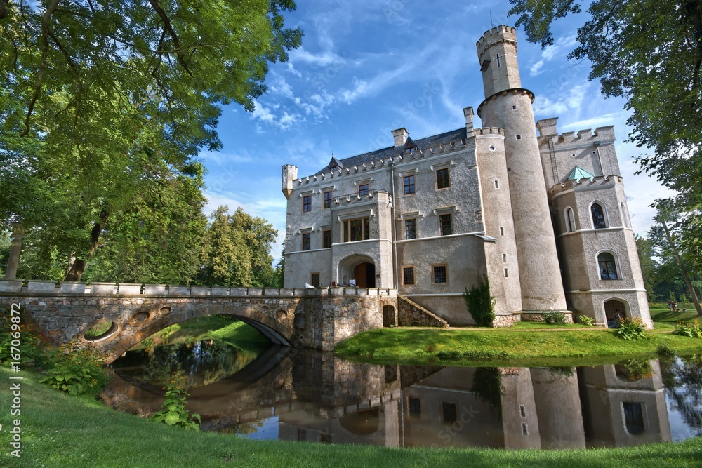 Obraz premium Neo-Gothic style castle surrounded by a moat in Karpniki, Poland