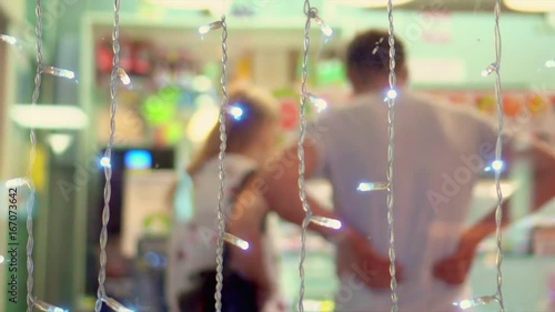 The man chooses to himself snack. The person stands in a queue of small shop. Indistinct shot.