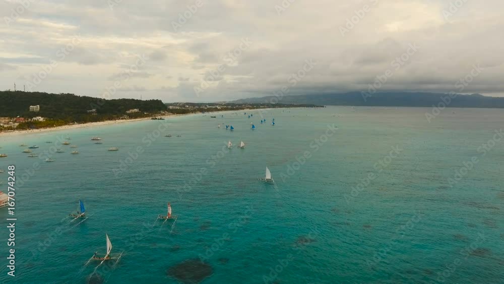 Aerial view: Sunset over the sea in the background boats,sailing boat, orange sky and islands.Tropical beach at sunset. Sailing boats at sunset in the sea. White sand beach. Travel concept. Beautiful Aerial view: Sunset over the sea in the background boats,sailing boat, orange sky and islands.Tropical beach at sunset. Sailing boats at sunset in the sea. White sand beach. Travel concept. Beautiful