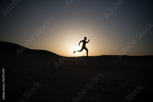 man running silhouette at sunset, young caucasian run in mountain