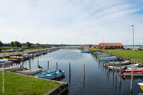 Denmark, Northern Jutland, Nibe. The towns marina/harbor with typical red wooden danish buildings and ships.