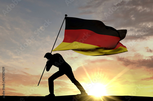 Germany flag being pushed into the ground by a male silhouette. 3D Rendering