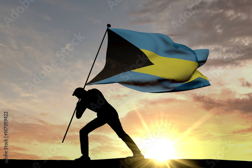 Bahamas flag being pushed into the ground by a male silhouette. 3D Rendering
