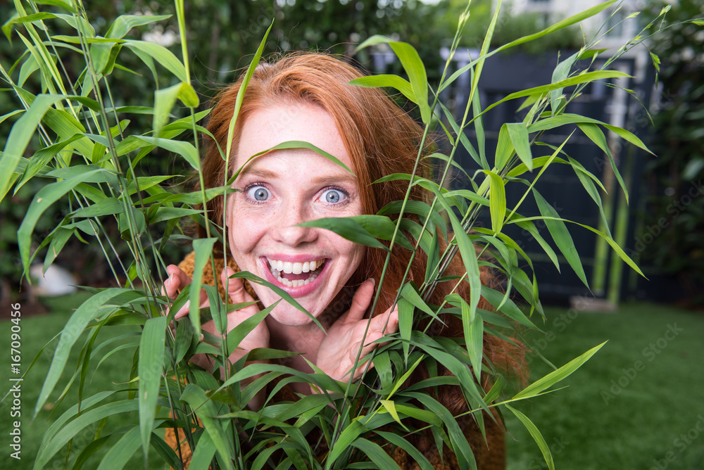 schöne rothaarige Frau freut sich über ihren Garten