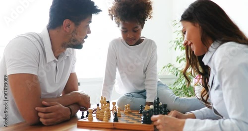 Happy family playing chess together at home