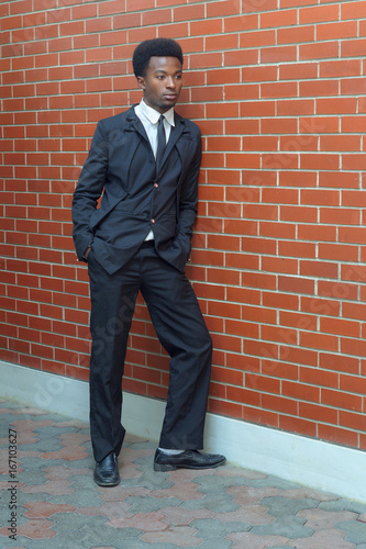 young businessman wearing suit and tie full length brick wall © Jacques Durocher