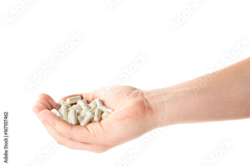 Image of a hand full of medical capsules on a white background