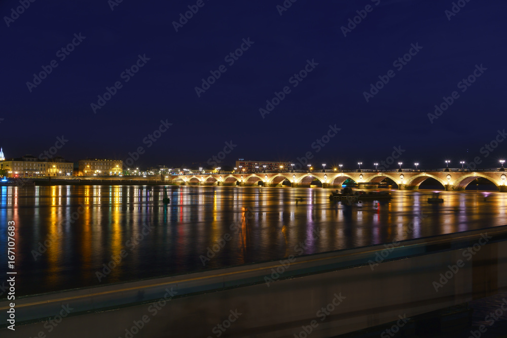 The beautiful Pont de pierre or Stone Bridge connecting the left and right banks of the Garonne River in twilight , Bordeaux , France