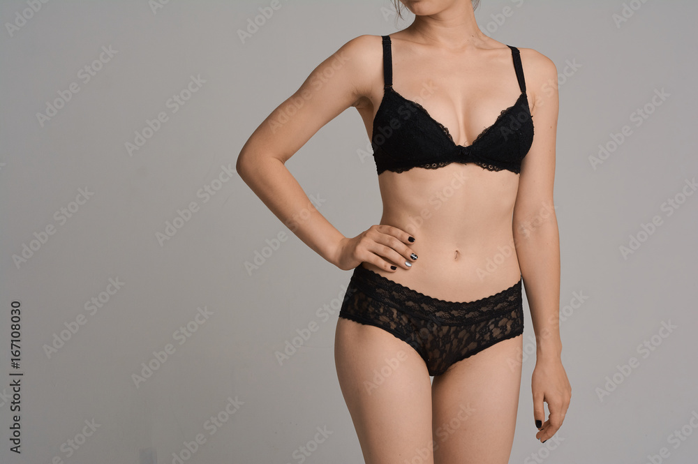 Fototapeta premium Beautiful girl with a sports figure in the studio on a white background. A beautiful figure, perfect underwear. Big breasts and a priest.