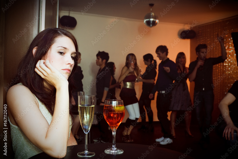 Young Woman Is Sitting Alone In A Nightclub - obrazy, fototapety, plakaty 