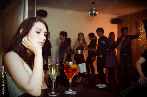 Canvas Print Young Woman Is Sitting Alone In A Nightclub