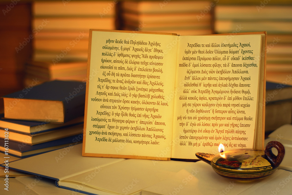 Open book illuminated by an oil lamp. The opening lines of The Iliad