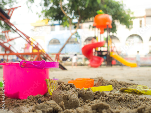 Wallpaper Mural Toys for sand digging it have a beautiful color Lay on the sand. the background is a playground. have a children and adults. Torontodigital.ca