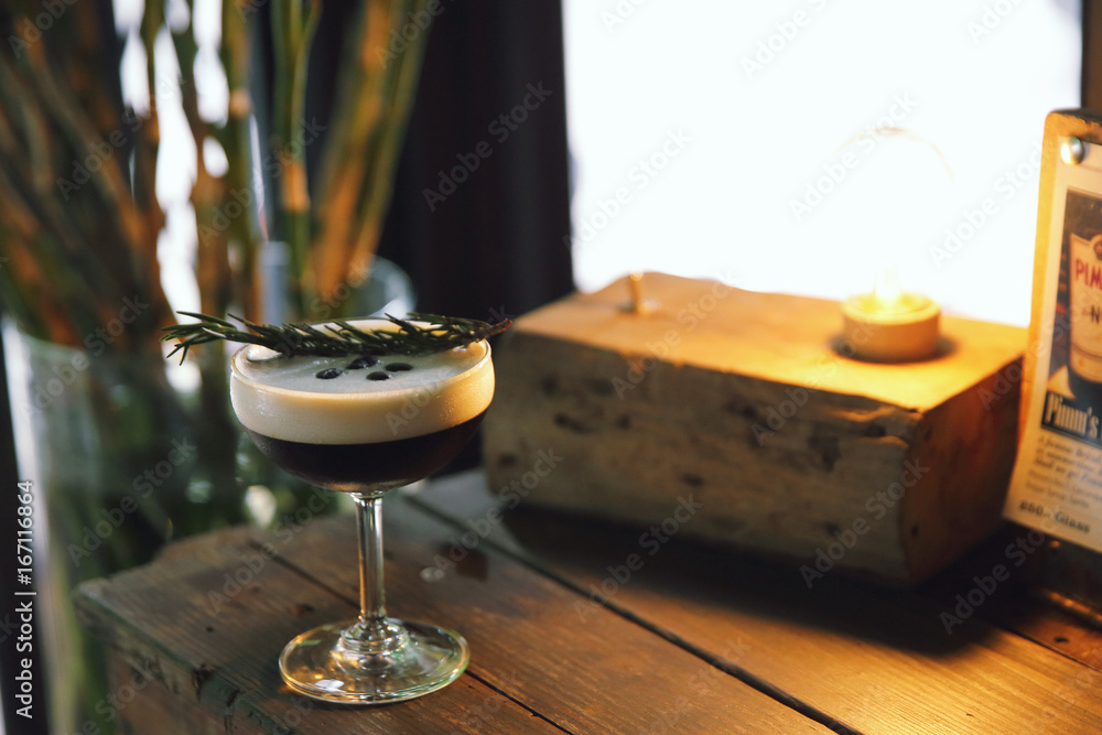 Coffee cocktail with coffee bean and rosemary on top with wood background Coffee cocktail with coffee bean and rosemary on top with wood background