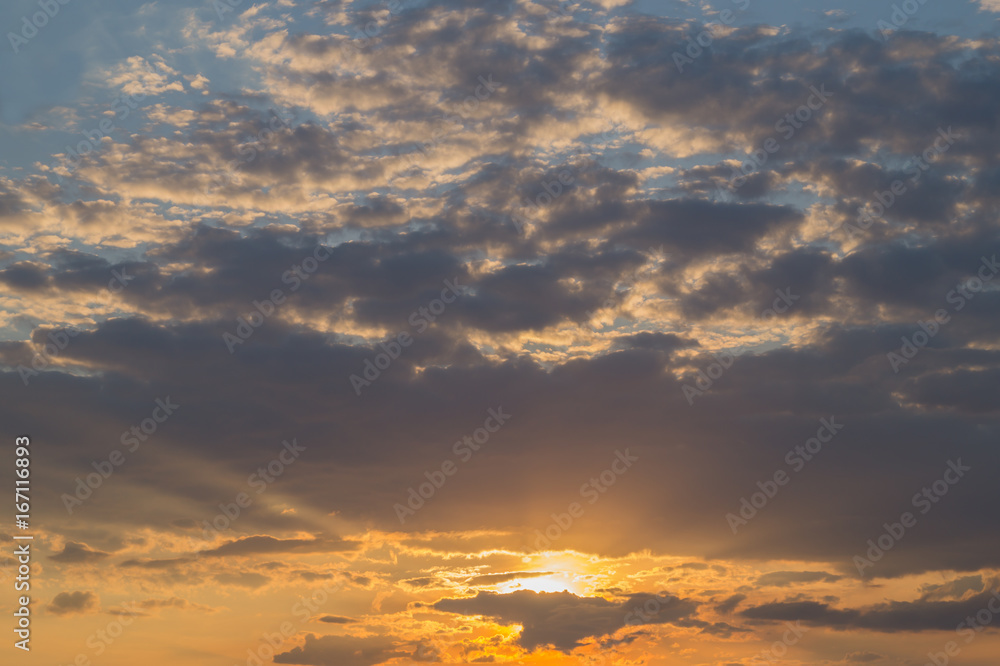 Bright  dark and yellow cloudy sky at sunset or sunrise