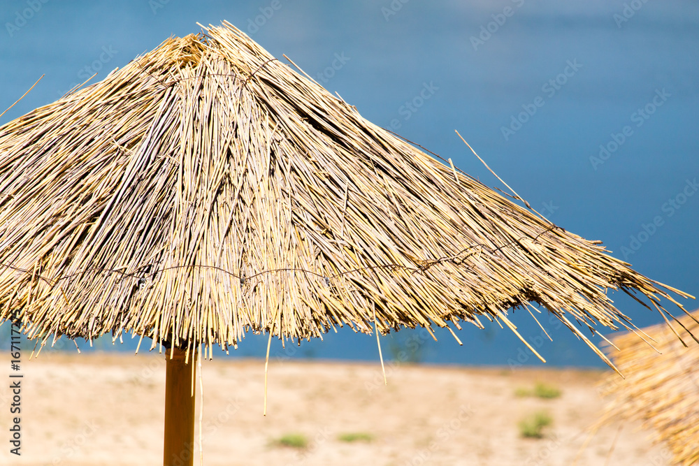 Straw sun umbrella on the beach