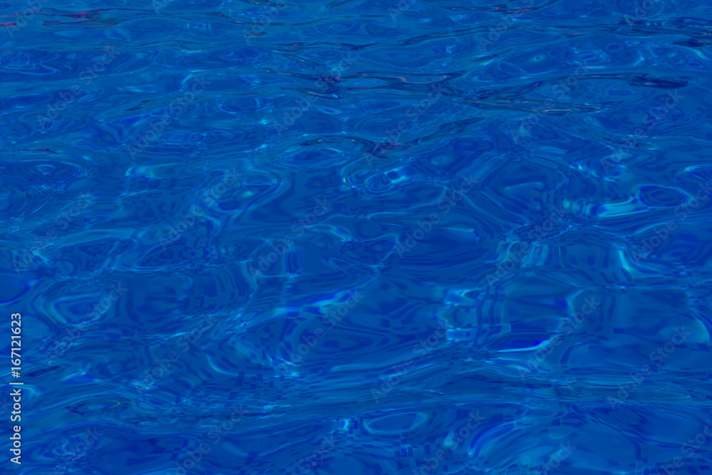 Naklejka premium Close-up of crystal-clear water with sunshine in the swimming pool, background, texture. Swimming conception.