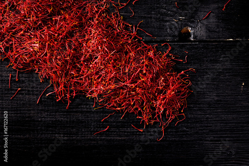 saffron crocus threads on black wooden board
