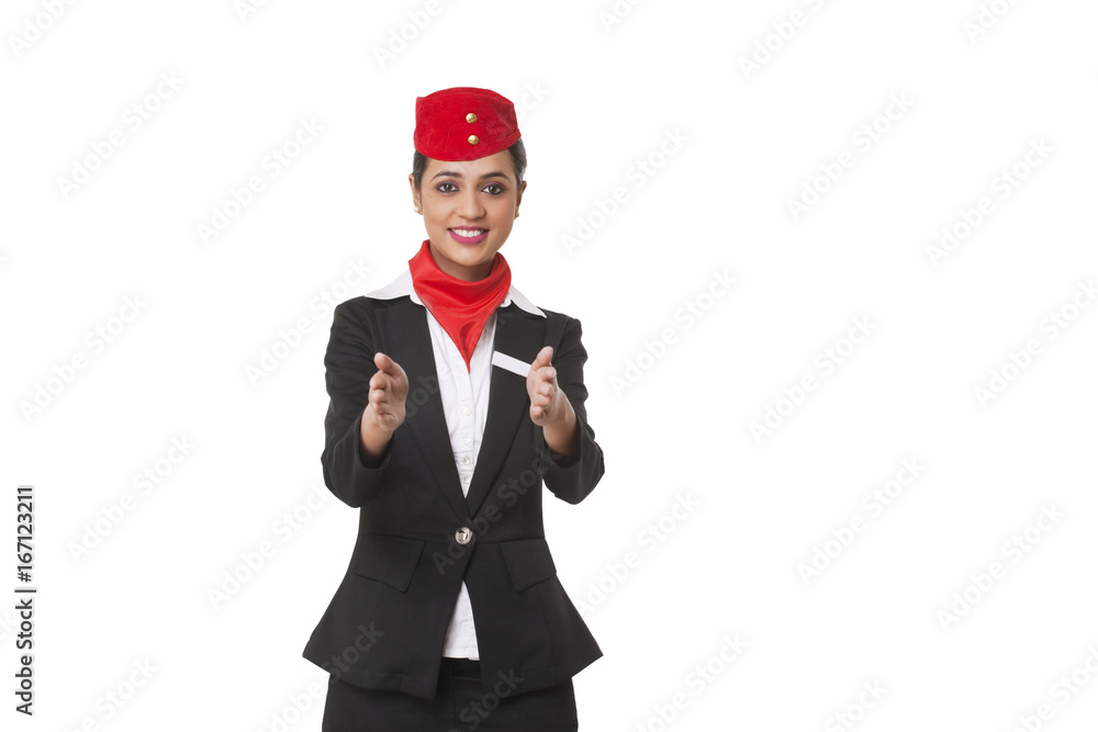 Flight attendant gesturing towards exits over white background 