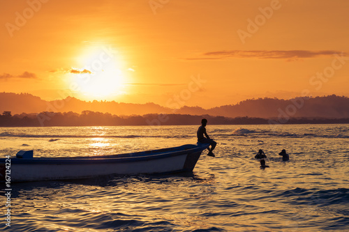People swimming at the beach in Puerto Viejo de Talamanca, Costa Rica, at sunset