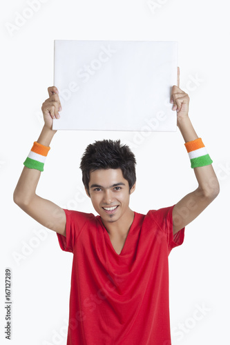 Photography Portrait of young boy in red t-shirt holding a blank placard over white backgrou