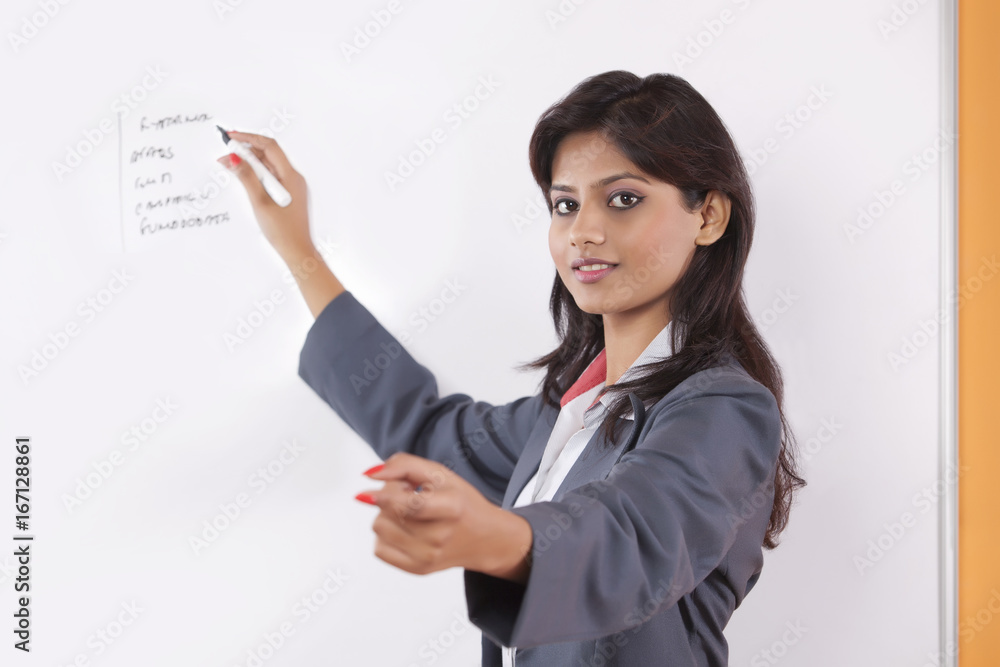 Portrait of female executive writing on white board Portrait of female executive writing on white board