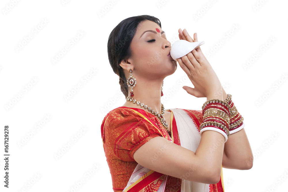 Bengali woman blowing on a conch shell Bengali woman blowing on a conch shell